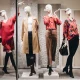 Retail store window featuring full-body mannequins styled with apparel