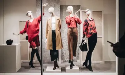 Retail store window featuring full-body mannequins styled with apparel